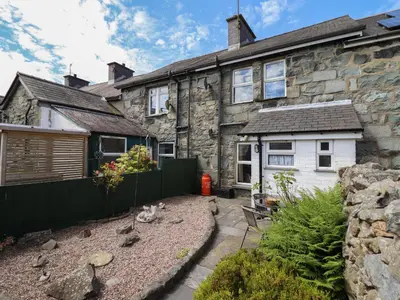 a stone house with a garden in front of it at Bodalaw in Trawsfynydd
