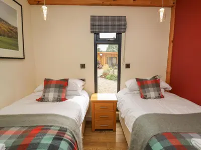 two twin beds in a room with a window at Pansi in Welshpool