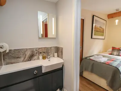 a bathroom with a sink and a bed at Pansi in Welshpool