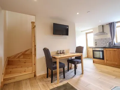 a kitchen and dining room with a wooden table and chairs at Hen Blaid in Oswestry