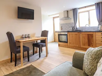 a kitchen and dining room with a table and chairs at Hen Blaid in Oswestry