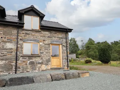 a stone house with a wooden door and windows at Hen Blaid in Oswestry