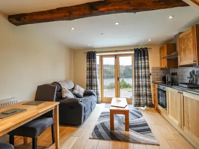 a living room with a couch and a table at Old Cart House in Oswestry
