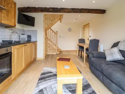 a living room with a couch and a table at Old Cart House in Oswestry