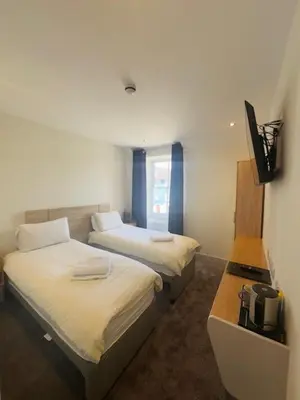 a hotel room with two beds and a television at The White Lion Hotel in Machynlleth