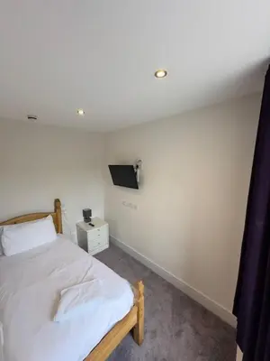 a bedroom with a bed and a tv on the wall at The White Lion Hotel in Machynlleth