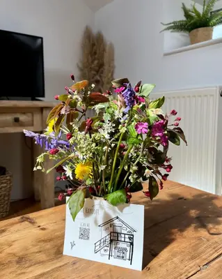 a bouquet of flowers in a card on a table at The Hayloft in Hereford