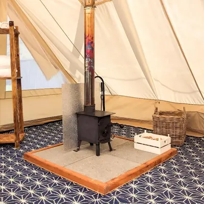 a stove in front of a tent at Tinker the Bell Tent at Pentref Luxury Camping in Penuwch