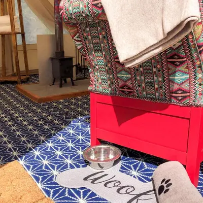 a red dresser with a bowl of food on the floor at Tinker the Bell Tent at Pentref Luxury Camping in Penuwch