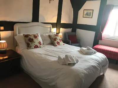 a bedroom with a white bed with two towels on it at Rhydspence in Hay-on-Wye