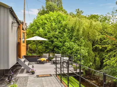 a patio with tables and chairs and an umbrella at Bechan Brook Hut in Bettws Cedewain