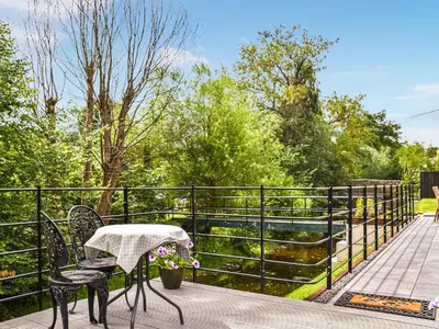 a patio with a table and chairs and a fence at Bechan Brook Hut in Bettws Cedewain