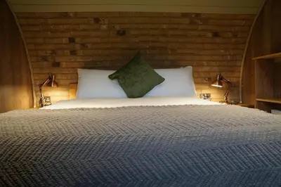 a bedroom with a large bed with two pillows at Hares View in Rhayader