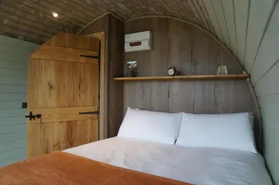 a bedroom with a bed with a wooden head board at Hares View in Rhayader