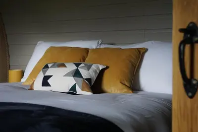 a bed with brown and white pillows at Badgers View in Rhayader