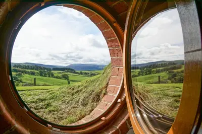 a circular window looking out at a green field at Badgers View in Rhayader