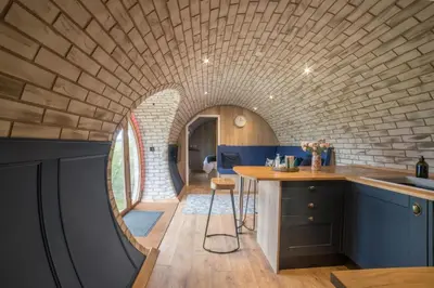a kitchen with a brick wall and a circular ceiling at Badgers View in Rhayader
