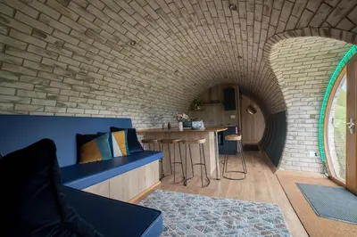 a room with a brick wall and a blue couch at Badgers View in Rhayader