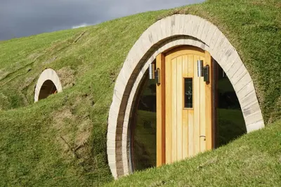 a grassy hill with a wooden door in it at Badgers View in Rhayader