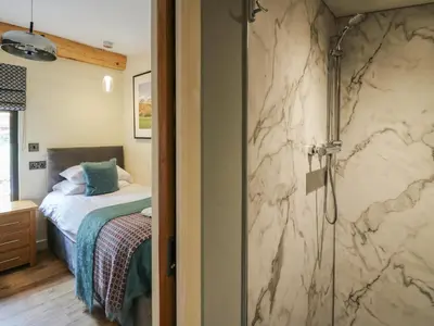 a bathroom with a shower and a bed in a room at Celyn in Welshpool