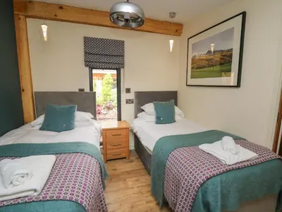 a bedroom with two beds and a window at Celyn in Welshpool