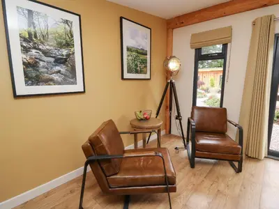 a living room with two chairs and a lamp at Rhosyn in Welshpool
