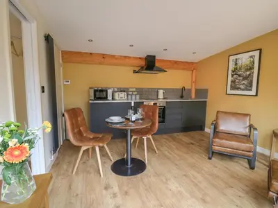 a kitchen and living room with a table and chairs at Rhosyn in Welshpool