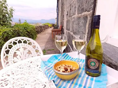 a table with two glasses of wine and a bowl of nuts at Stylish home from home with great views in Harlech