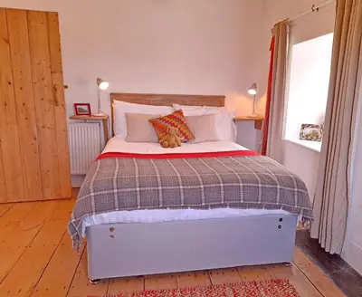 a bedroom with a bed with a teddy bear laying on it at Stylish home from home with great views in Harlech