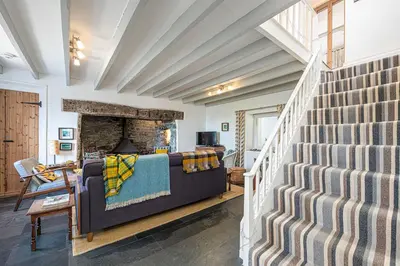 a living room with a staircase and a couch at Stylish home from home with great views in Harlech