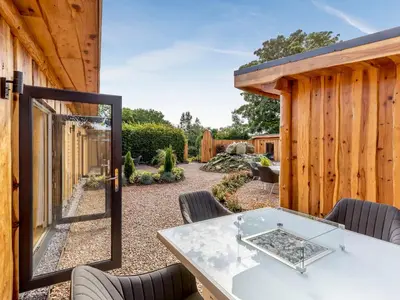 a patio with a table and chairs and a fence at Rhosyn - Uk40260 in Llangadfan