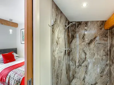 a bathroom with a stone wall next to a bed at Fioled - Uk40267 in Llangadfan
