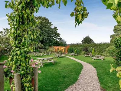 a garden with picnic tables and benches in the grass at Daffodil - Uk40266 in Llangadfan