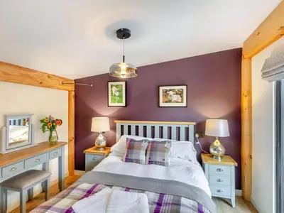 a bedroom with a bed and a purple wall at Daffodil - Uk40266 in Llangadfan
