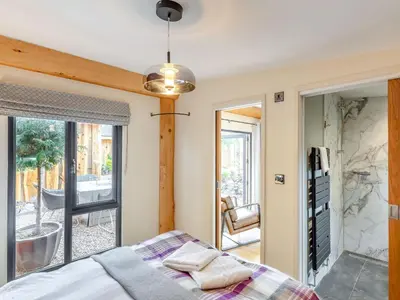 a bedroom with a bed and a sliding glass door at Daffodil - Uk40266 in Llangadfan
