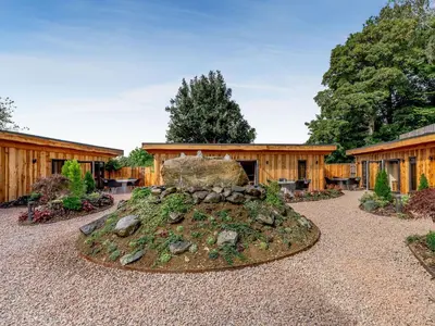 a garden with a rock in front of a building at Daffodil - Uk40266 in Llangadfan