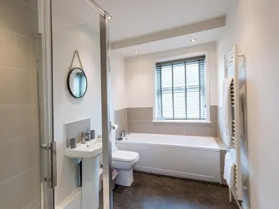 a bathroom with a tub and a toilet and a sink at Perfectly located 2 bed townhouse in Shrewsbury - Pass the Keys in Shrewsbury