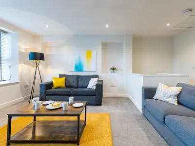 a living room with two blue couches and a table at Perfectly located 2 bed townhouse in Shrewsbury - Pass the Keys in Shrewsbury