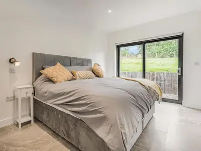a bedroom with a large bed with a large window at Jacobs Plock in Leintwardine