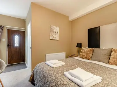 a bedroom with a bed with two towels on it at Curly Tail Accommodation in Bishops Castle