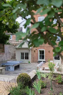 a patio with a ping pong table in front of a brick building at Ludlow Townhouse in Ludlow