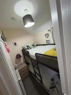 a small room with two bunk beds and a light at Hill View Cottage in Bala