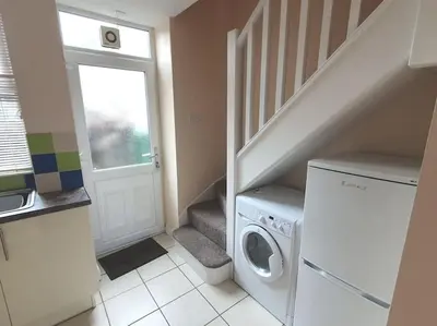 a laundry room with a washing machine and a staircase at Hill View Cottage in Bala