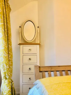 a bedroom with a dresser with a mirror on it at Ty Cwtch in Dolgellau
