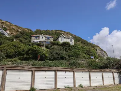 a house on top of a hill with a fence at Windycroft in Barmouth