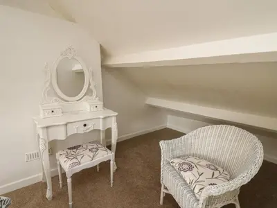 a room with a dressing table and a chair and a mirror at Rowan Cottage in Builth Wells