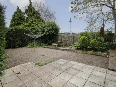 a garden with a table and a picnic table at Rowan Cottage in Builth Wells