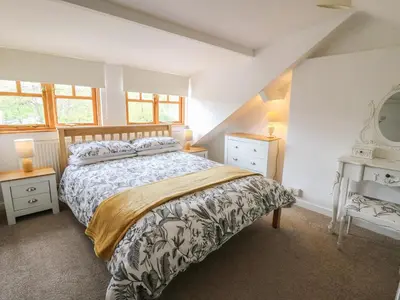 a bedroom with a bed and two night stands at Rowan Cottage in Builth Wells