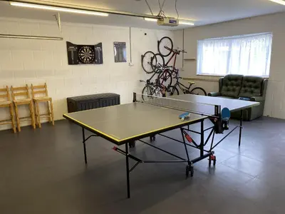 a ping pong table in a room with a ping pong ball at Angorfa family holiday home with games room in Tywyn