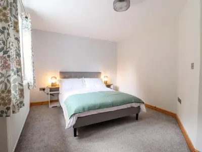 a bedroom with a bed and two lamps on a table at Llys Tirion in Bala